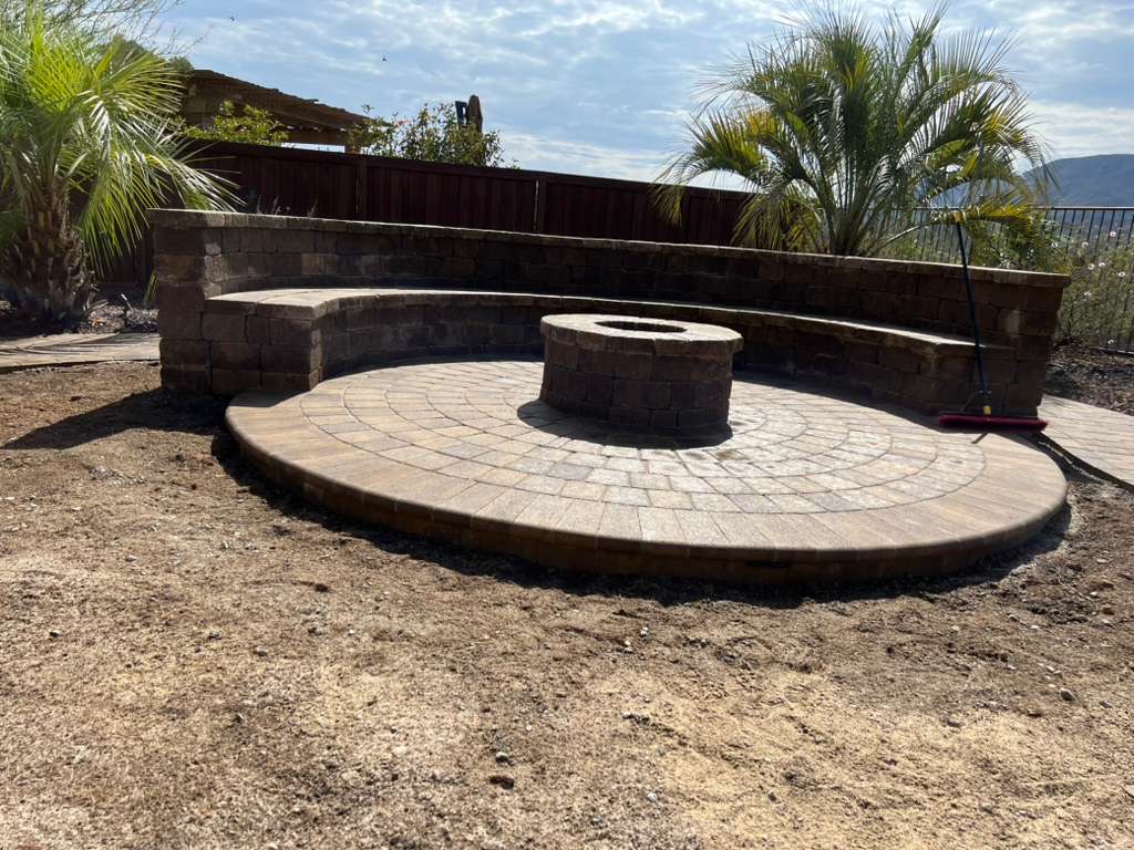 Circular paver fire pit with curved stone seating wall
