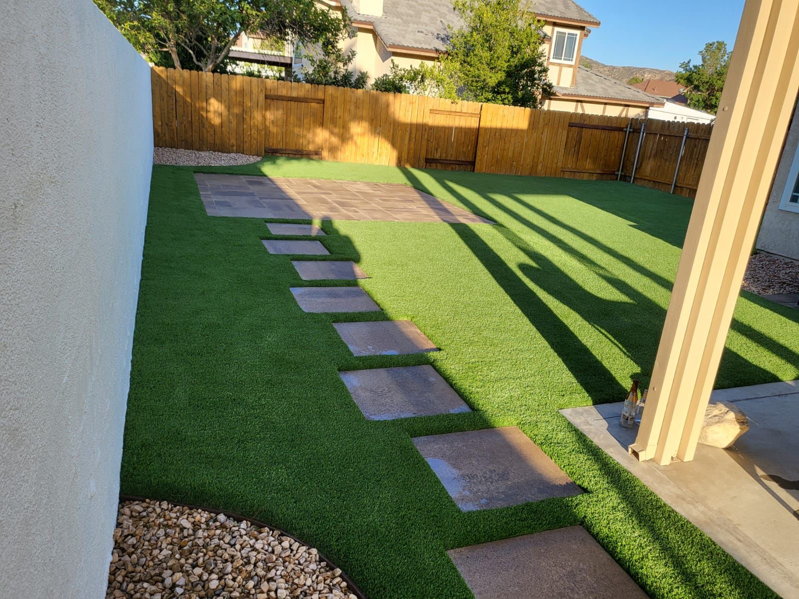 Backyard turf with stepping stones and paver patio