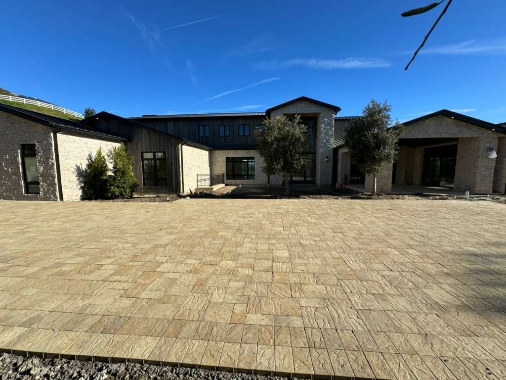 Modern farmhouse estate with expansive paver courtyard