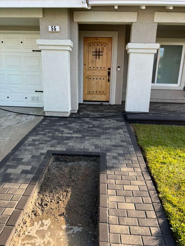 Front entry walkway with gray pavers and planter cutout